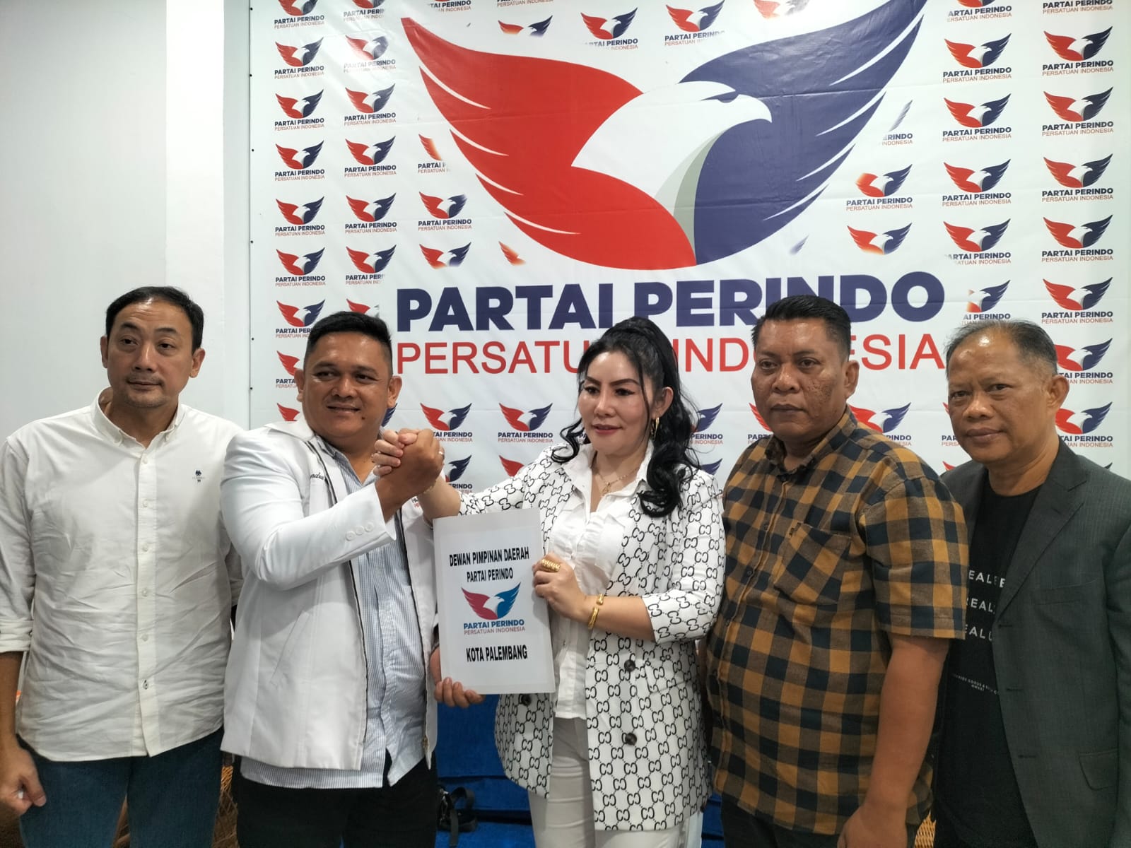 Candra Wahyudi Menerima Fitriana/ Pingky Mengambil Berkas Pendaftaran Bacawako Palembang di kantor DPD Perindo Kota Palembang
